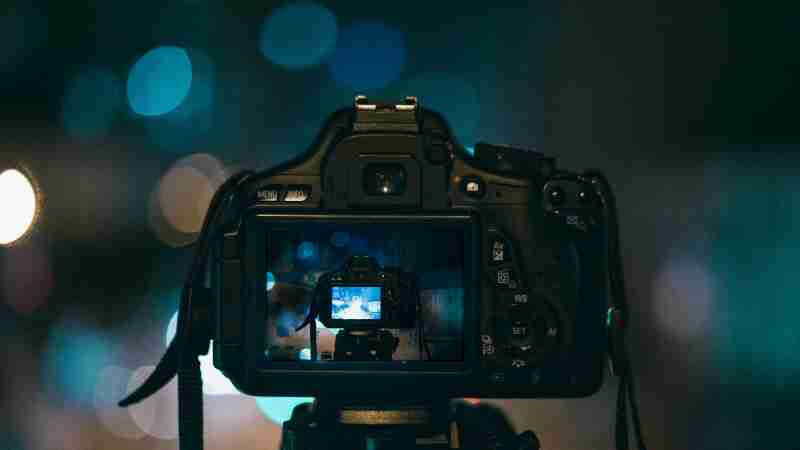 Close-up of a DSLR camera capturing a bokeh background in a dimly lit setting, illustrating night photography., tags: 1839 awards gewinner:innen und - pexel