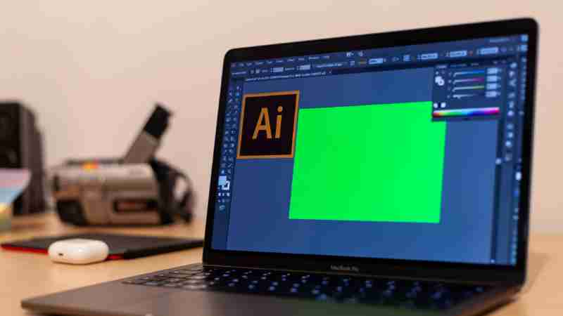 Close-up of a MacBook Pro with Adobe Illustrator open on a desk, showcasing creative workspace essentials., tags: die von der ki - pexel